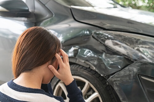 woman looking at her car after a hit and run accident in Colorado